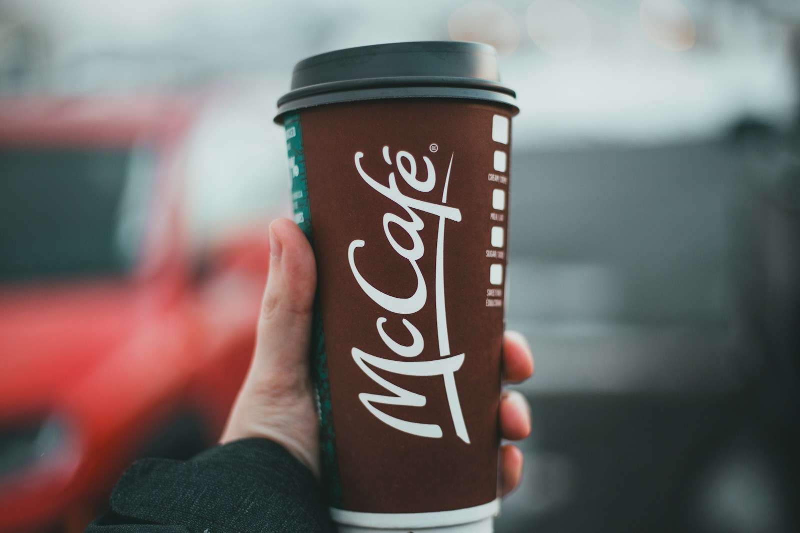 McCafé, person holding red and white coca cola disposable cup