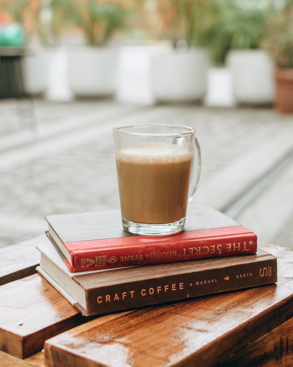 a glass of coffee on top of books